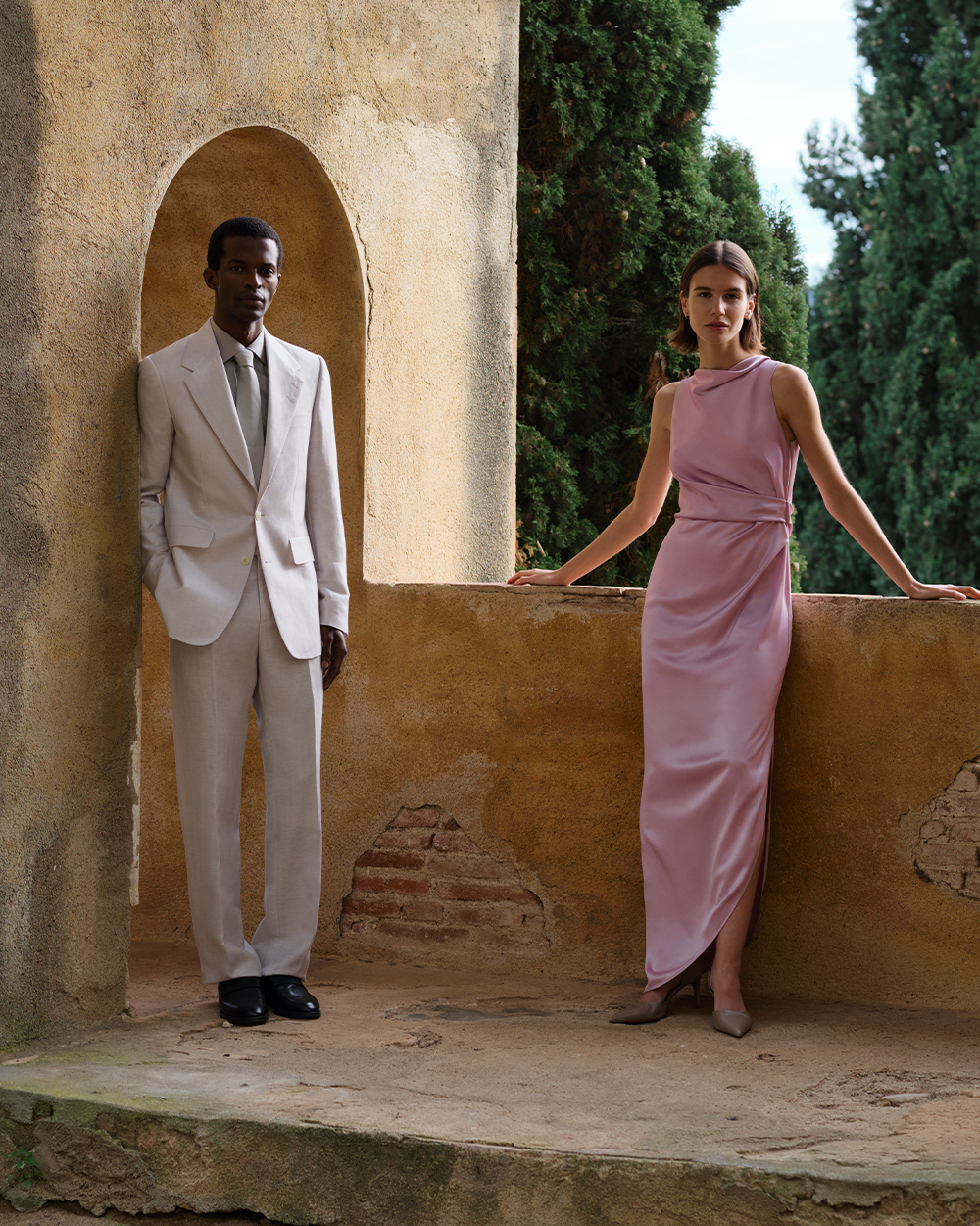 Man in beige suit and woman in pink satin dress